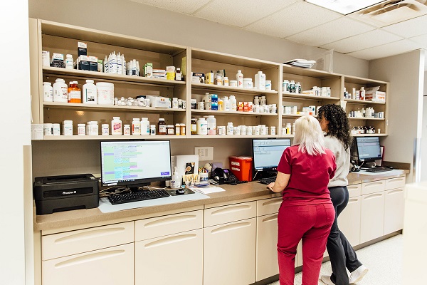 Two women standing in the storage room of veterinary clinic